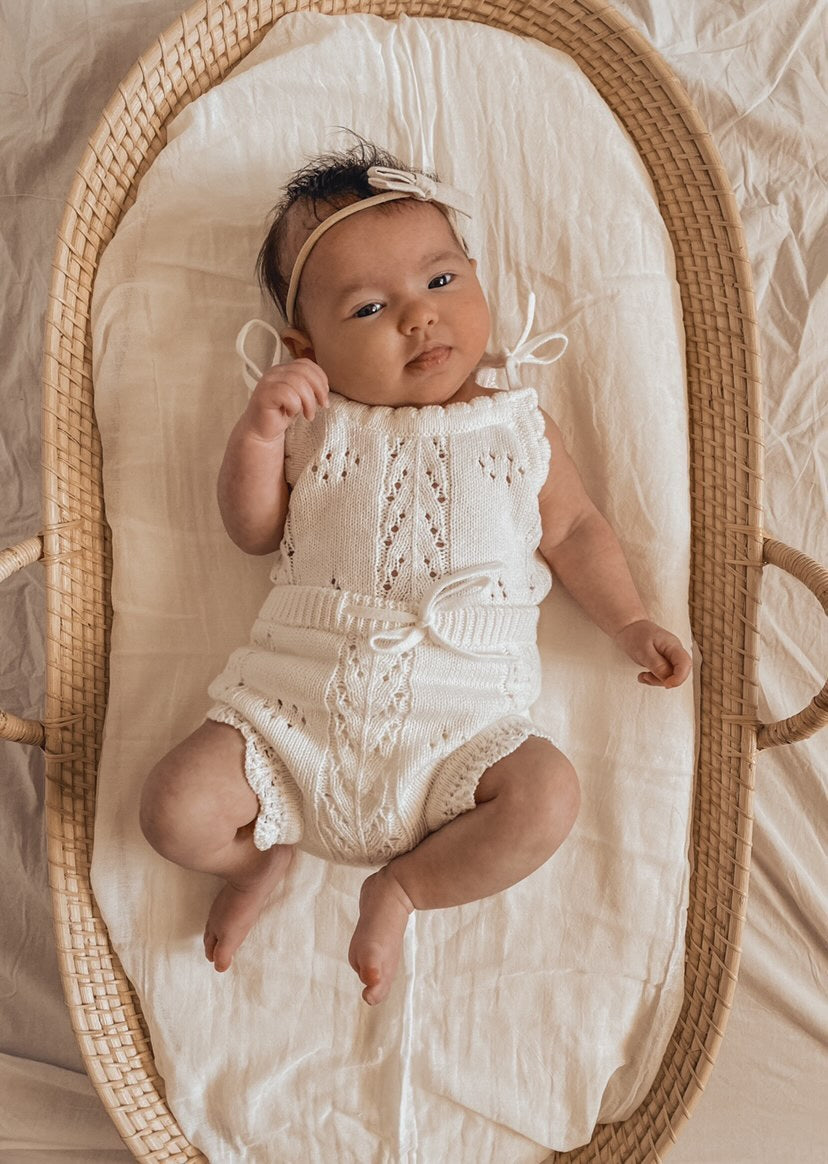 Little B's Knitted Cotton Pointelle Set in Milk on a baby in a bassinet