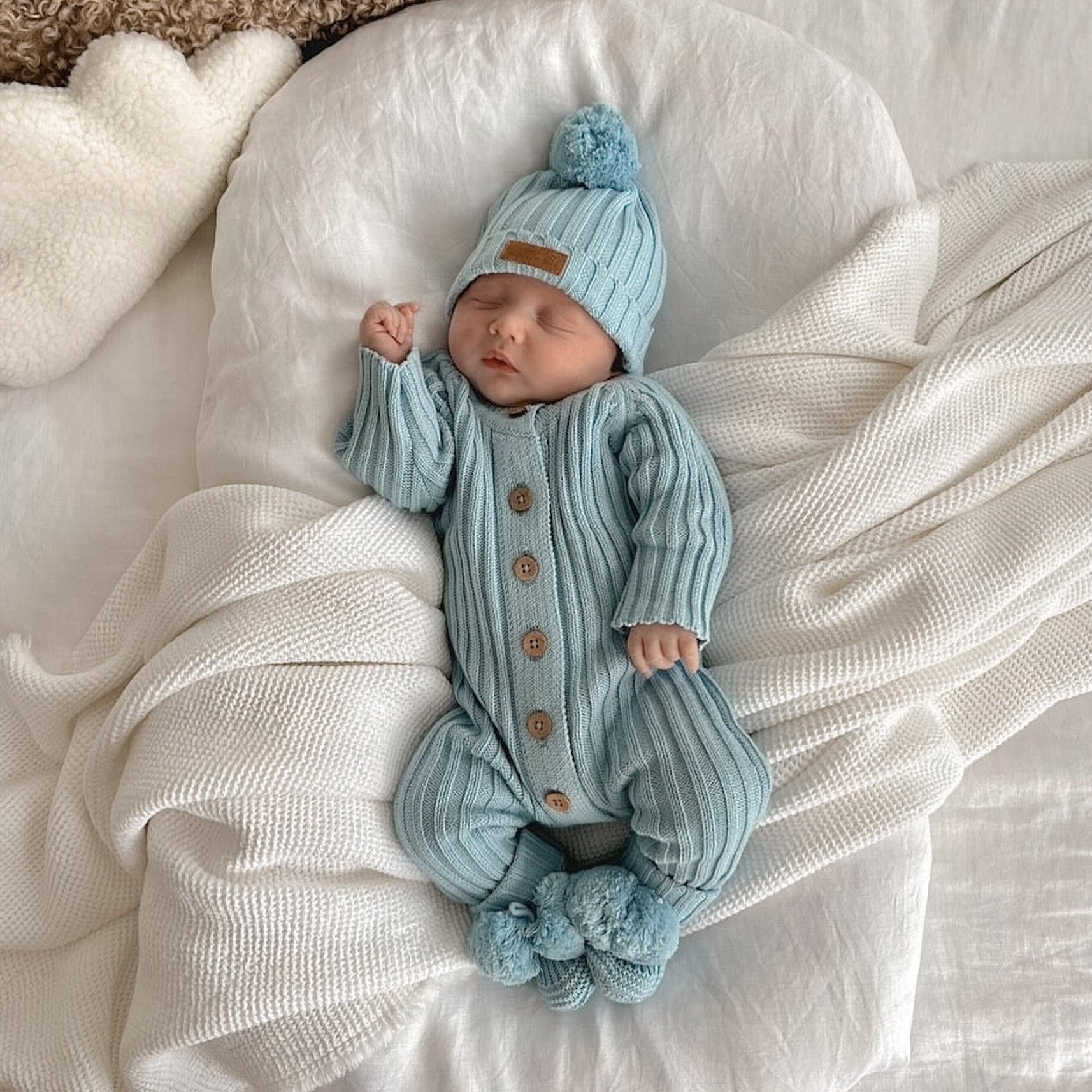 Newborn baby sleeping in a blue Knitted Cotton Ribbed Beanie from Little B's Retail