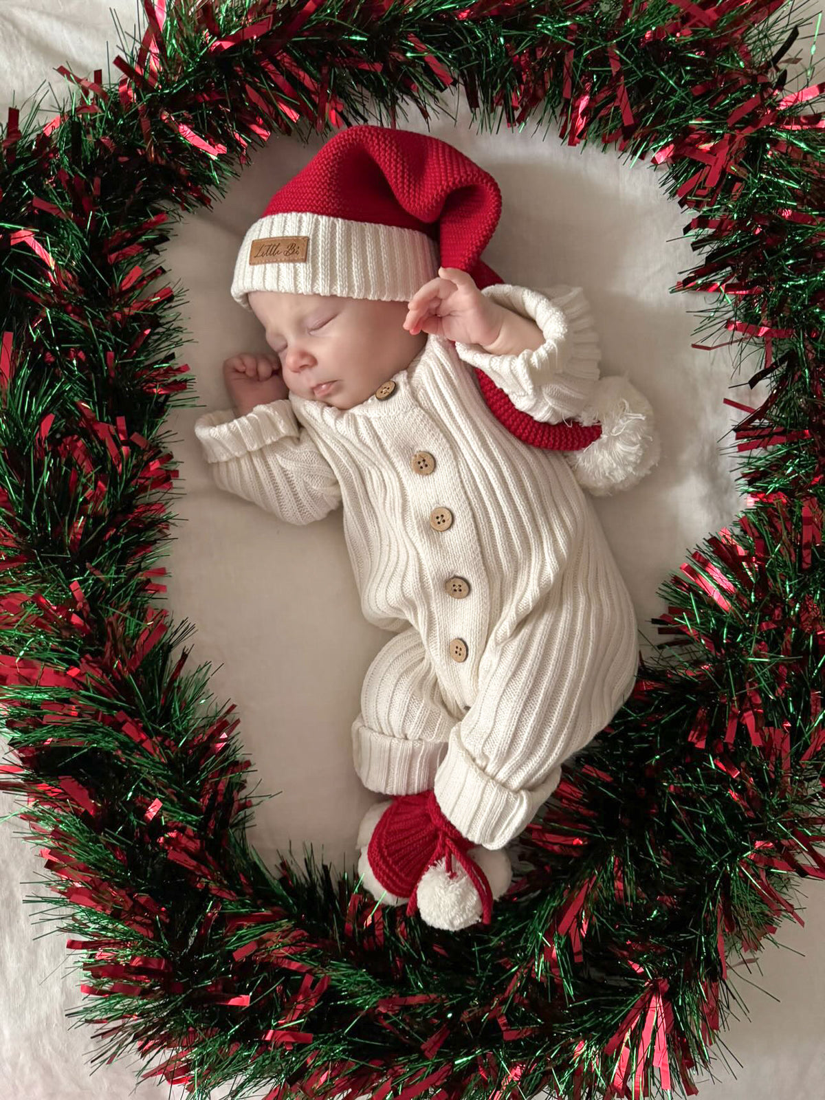 Sleeping baby in a Little B's Knitted Cotton Classic Christmas Beanie Red and white outfit