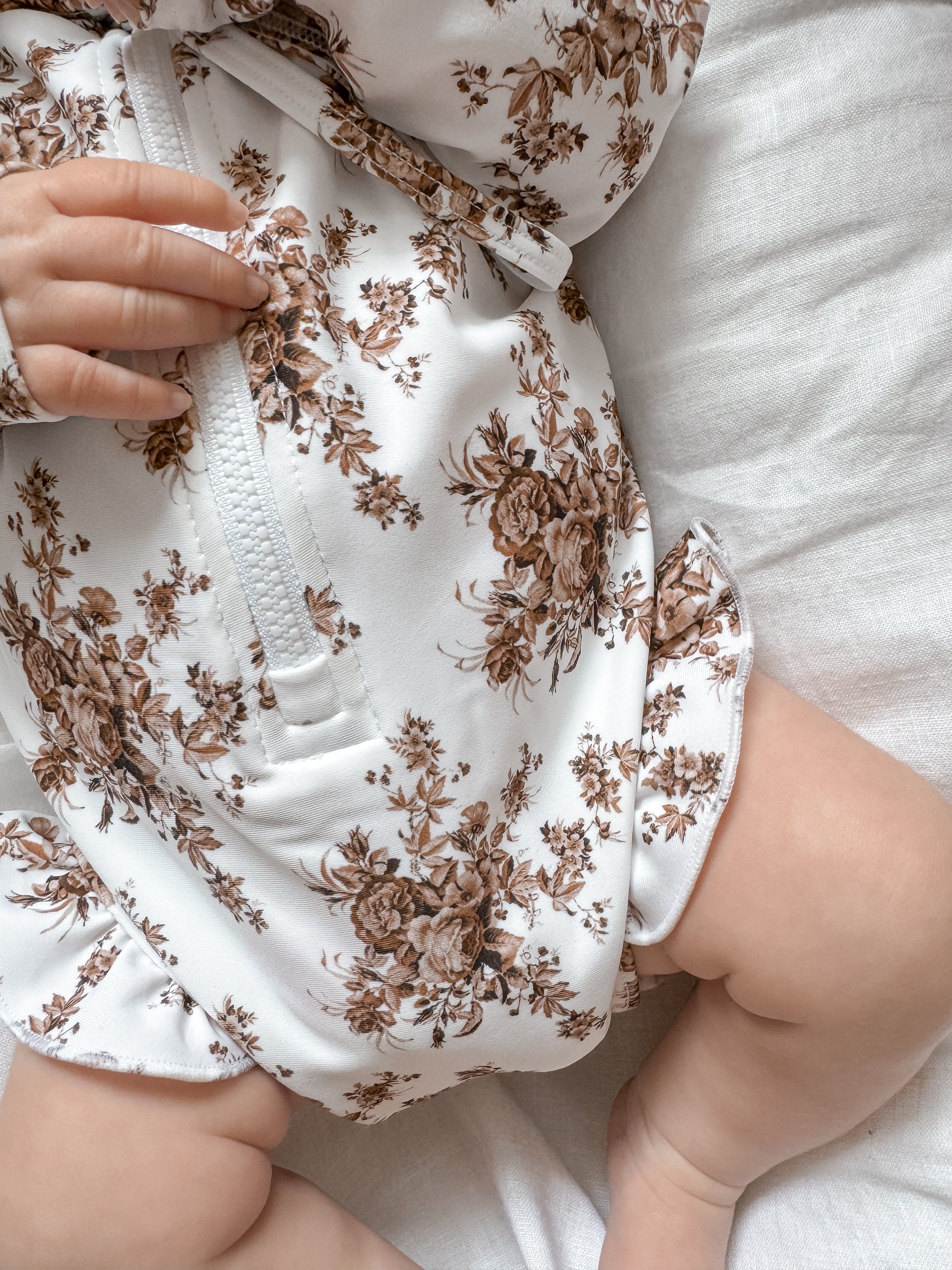 Little B's Bella swimwear with hat, white with brown floral print, on a baby